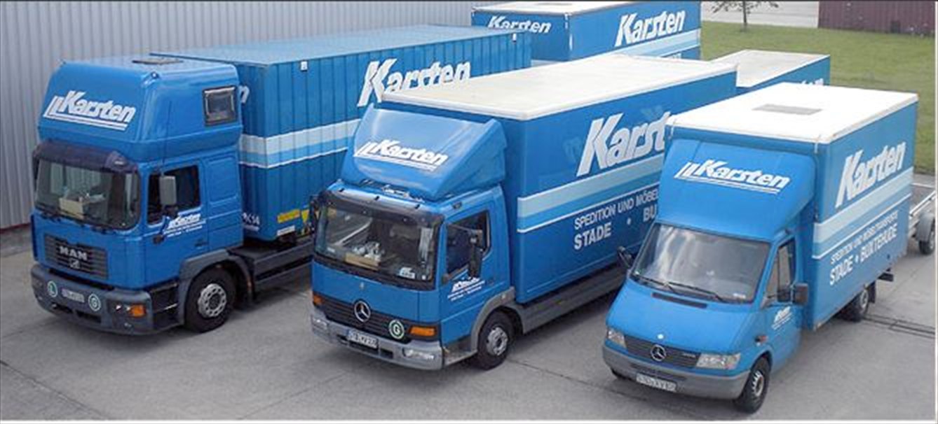 Drei blaue Möbeltransporter der Karsten GmbH & Co. KG auf dem Betriebshof in Stade