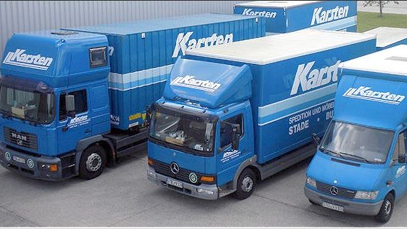 Drei blaue Möbeltransporter der Firma Karsten auf dem Betriebshof in Stade