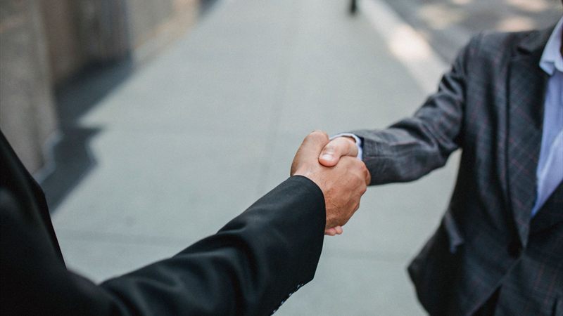 Handschlag zwischen zwei Personen als Zeichen einer festen Vereinbarung