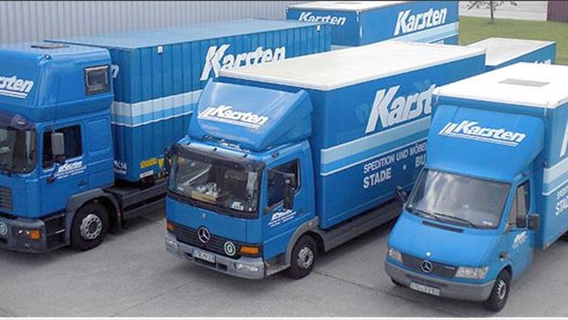 Drei blaue Möbeltransporter der Firma Karsten auf dem Betriebshof in Stade